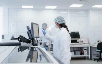 Un scientifique en tenue de protection utilise un équipement dans un laboratoire moderne.
